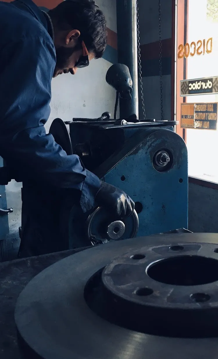 Mecánico rectificando disco de freno en máquina especializada