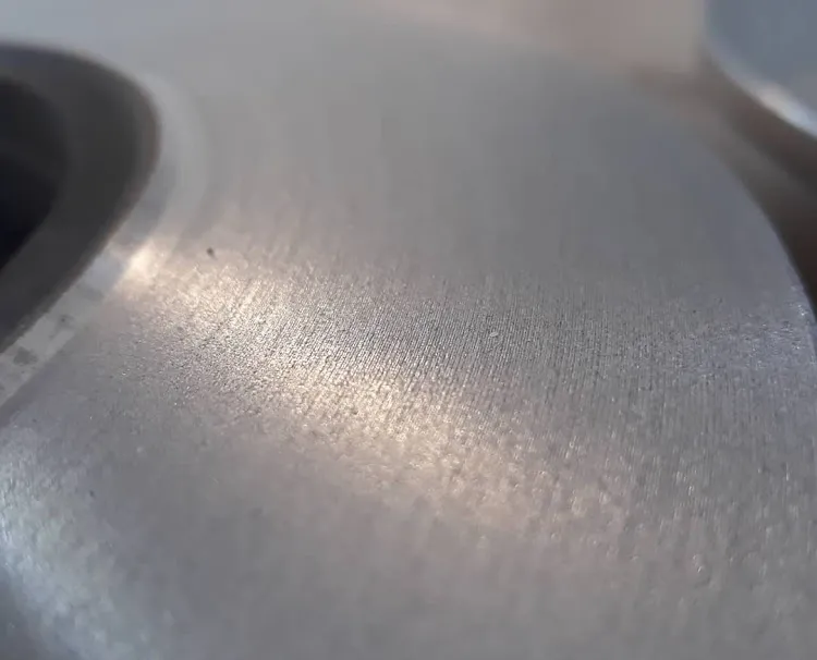 Primer plano de disco de freno rectificado mostrando superficie uniforme