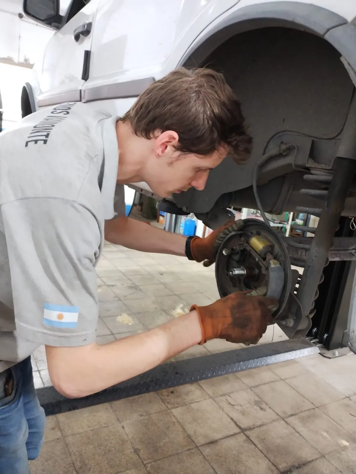 Mecánico realizando service de frenos en vehículo del cliente